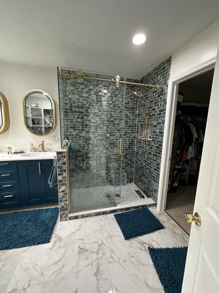 Completed Carmel bathroom remodel showing vanity and full shower with custom glass shower enclosure new tile finishes