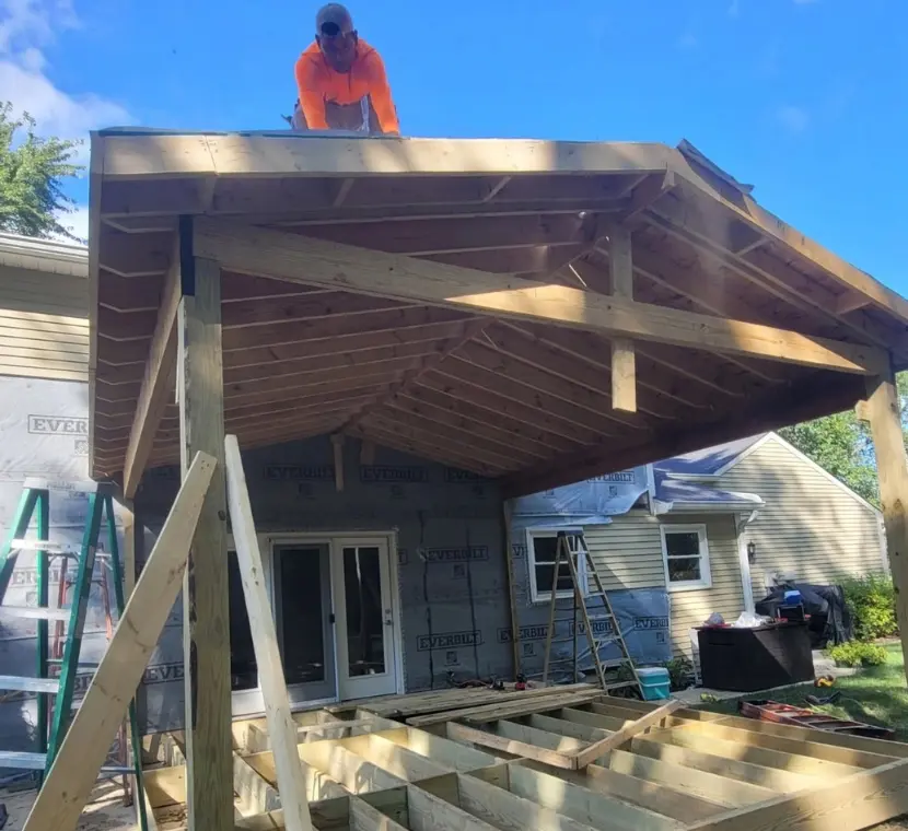 Builder installing roof sheathing for a screened porch addition by Ntegrity Builders LLC in Carmel, Indiana, showcasing craftsmanship and attention to detail.