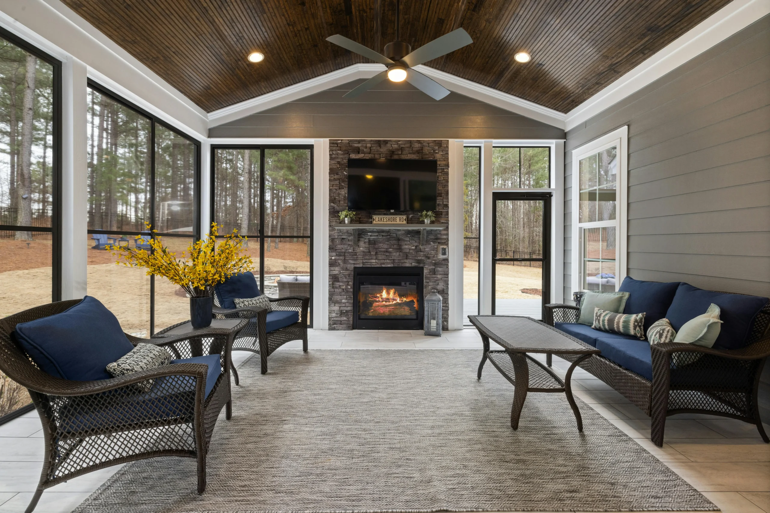 Screened porch with fireplace and vaulted wood ceiling by a Central Indiana design build contractor