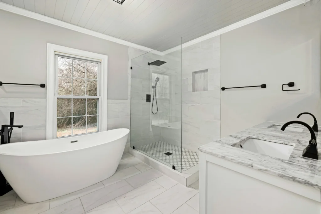 Finished primary bathroom remodel with freestanding tub, glass shower, tile, and double vanity in Central Indiana