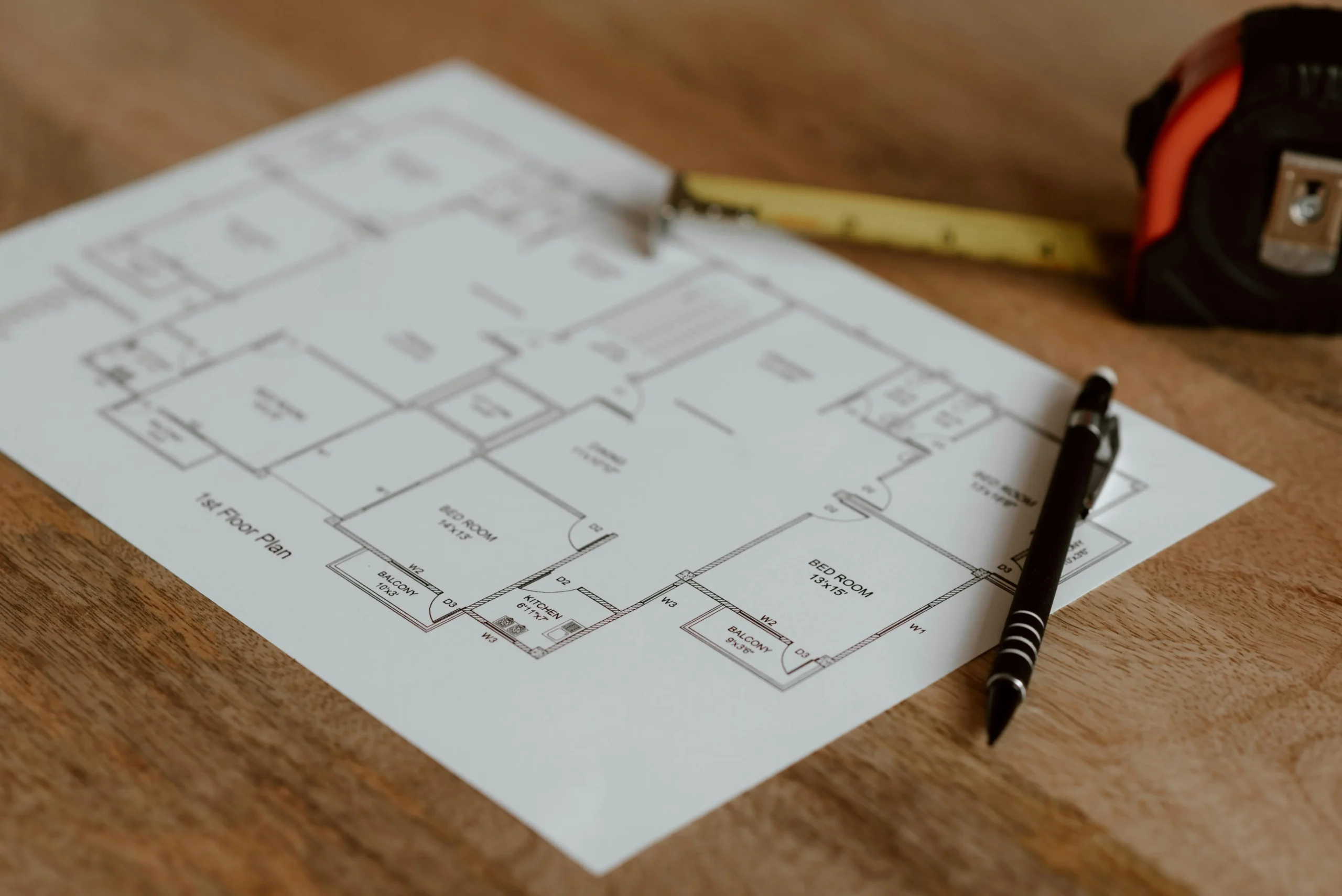 Floor plan with pencil, tape measure, and glasses for planning a remodel in Central Indiana