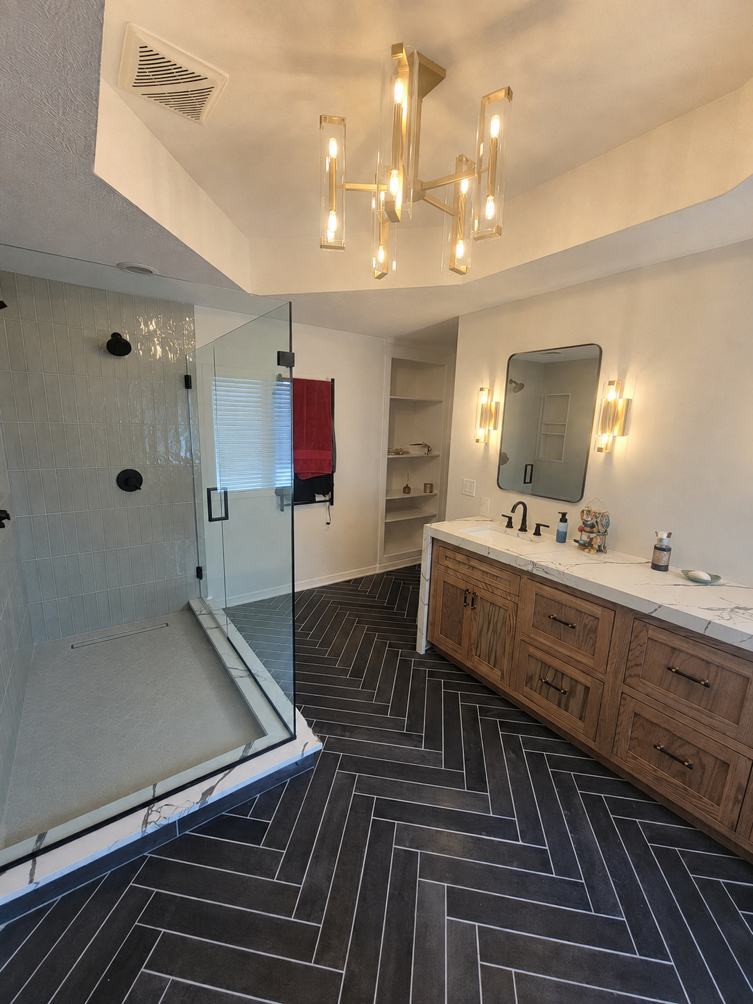 Primary bathroom remodel in Carmel with a glass shower, custom white oak vanity, and heated wood-look herringbone tile floor