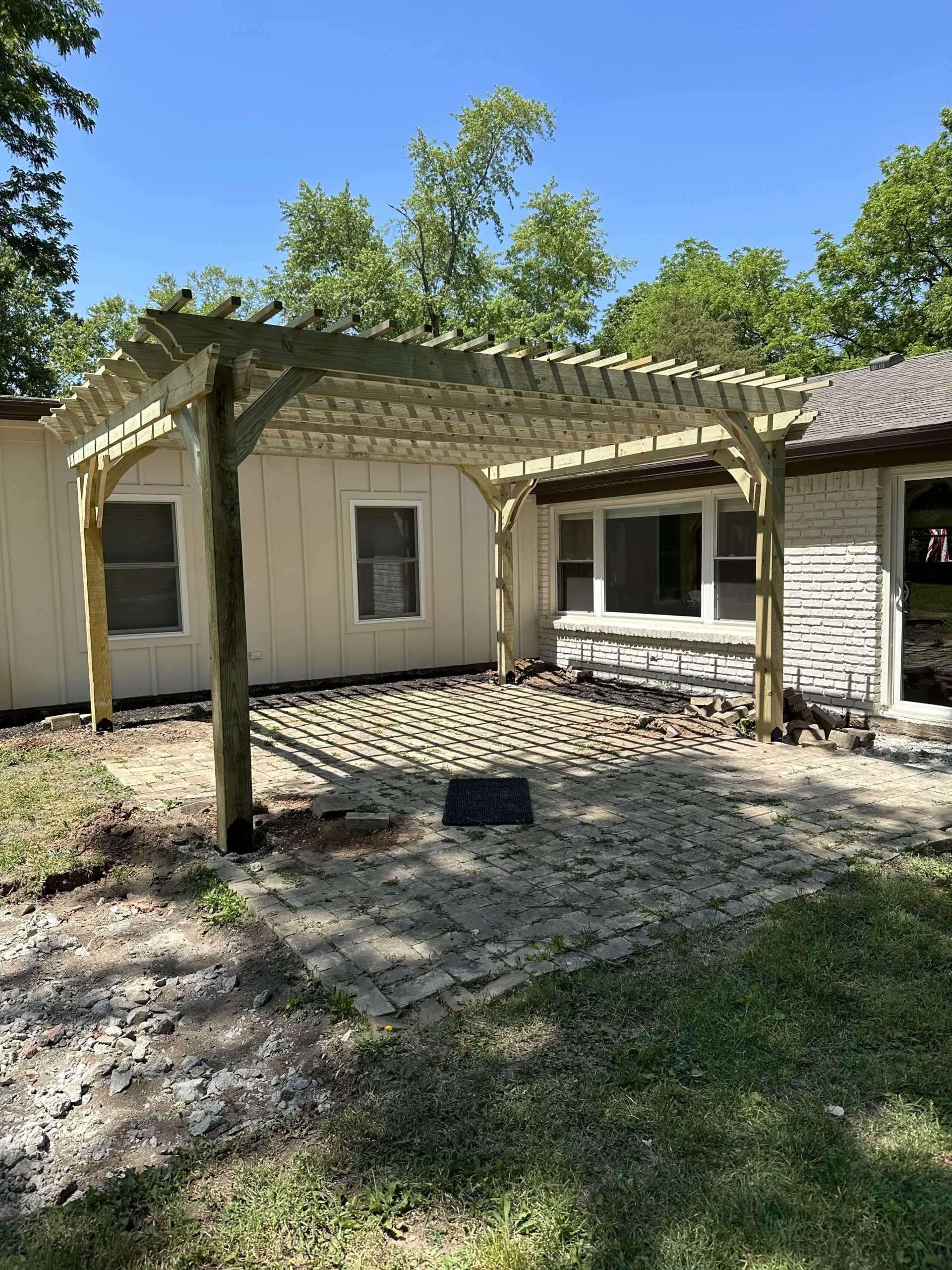 Completed wood pergola framing before the installation of a stamped concrete patio in Carmel, Indiana.