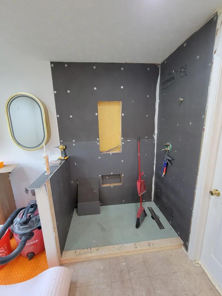 Shower walls covered with backer board during corrective construction