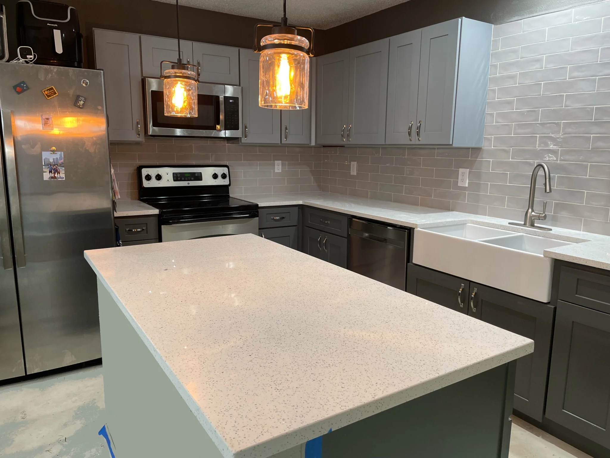 Finished kitchen remodel with gray cabinetry, quartz countertops, and pendant lighting in Fishers Indiana