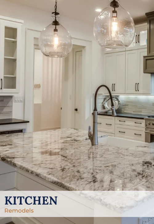 Bright remodeled kitchen with white cabinetry, large stone island, pendant lights, and modern finishes