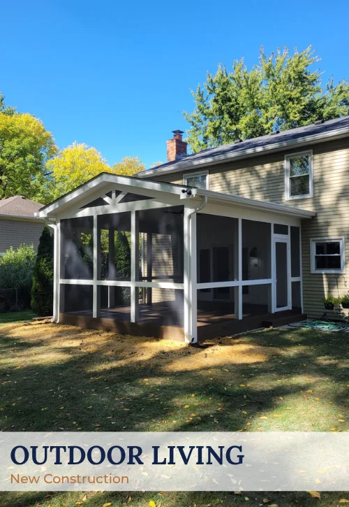 Screened outdoor living addition with covered roof, dark screen panels, and backyard access