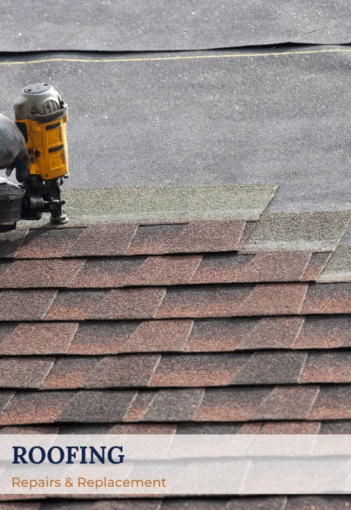 Asphalt shingle roof installation with roofer securing shingles using a pneumatic nail gun