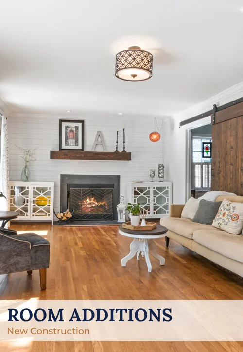 Finished room addition with fireplace, built-in storage, barn door, hardwood floors, and seating area