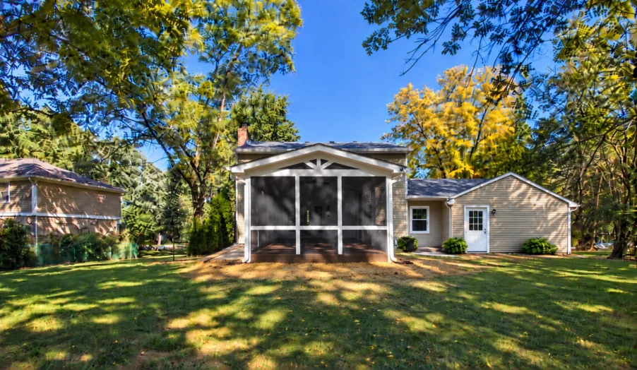Front view of completed screened porch addition with dark screening, white framing, and a gabled roof in Carmel Indiana.