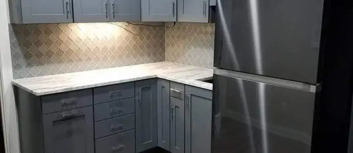 Basement remodel - kitchenette - with gray shaker cabinets, quartz countertop, and stainless steel refrigerator by Ntegrity Builders in Fishers, Indiana.