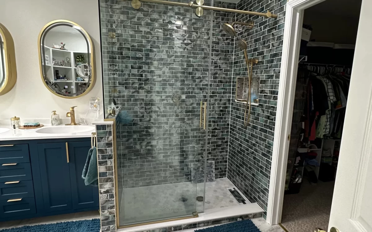 Completed Carmel bathroom remodel showing vanity and full shower with custom glass shower enclosure new tile finishes