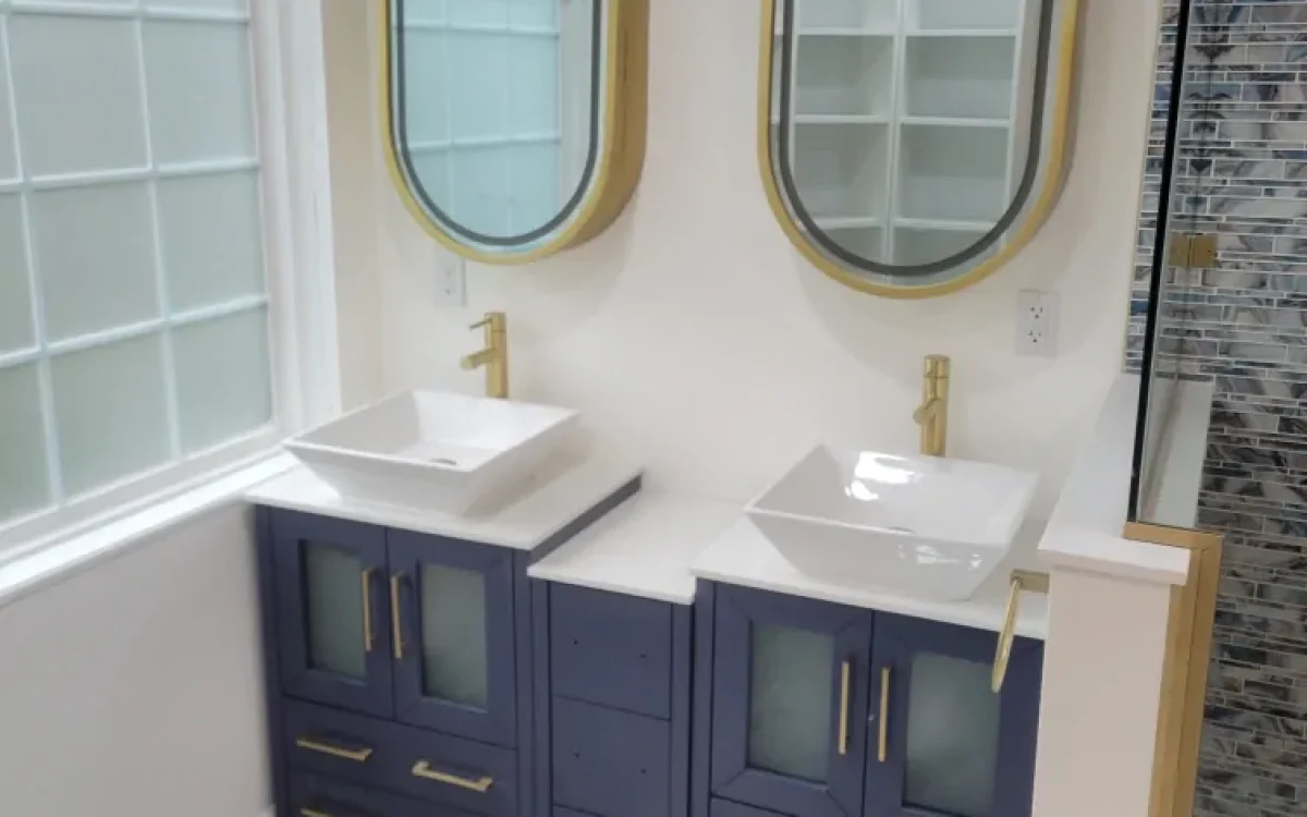 Finished blue vanity with two vessel sinks, round mirrors, and gold-tone hardware